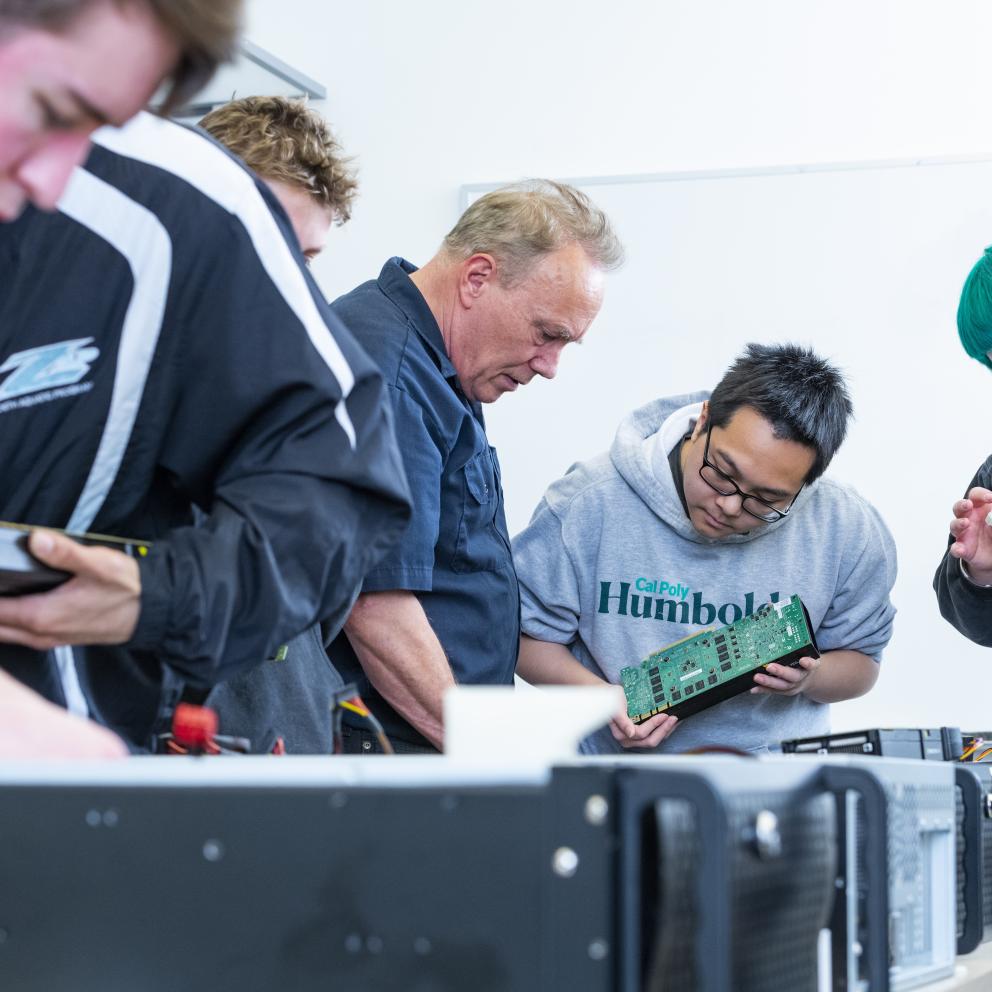 Faculty and students building computer together